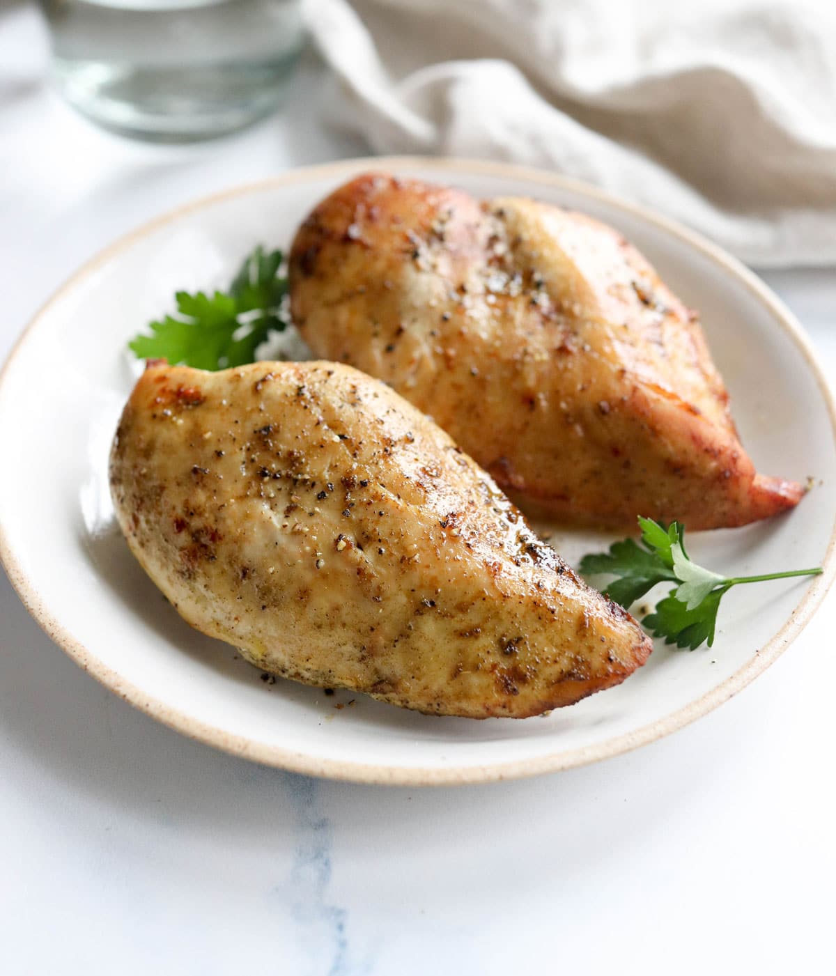 air fryer chicken breasts on plate with parsley