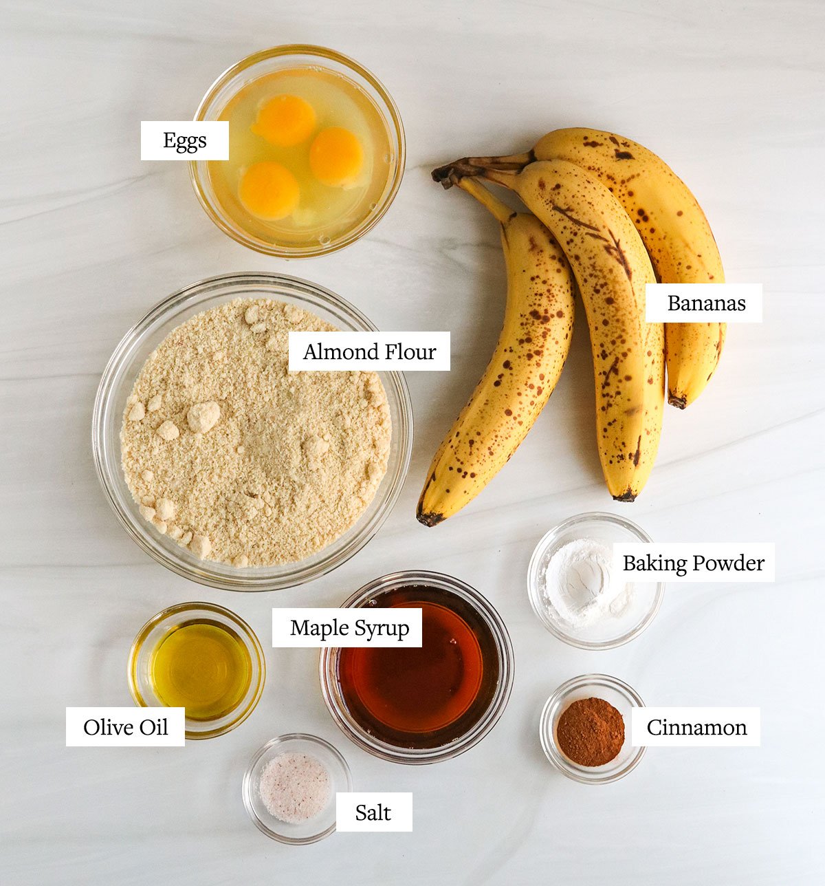 almond flour banana bread ingredients labeled in glass bowls.