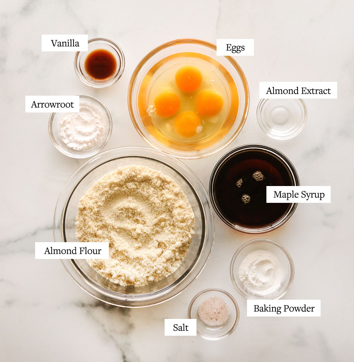 almond flour cake ingredients labeled in glass bowls.