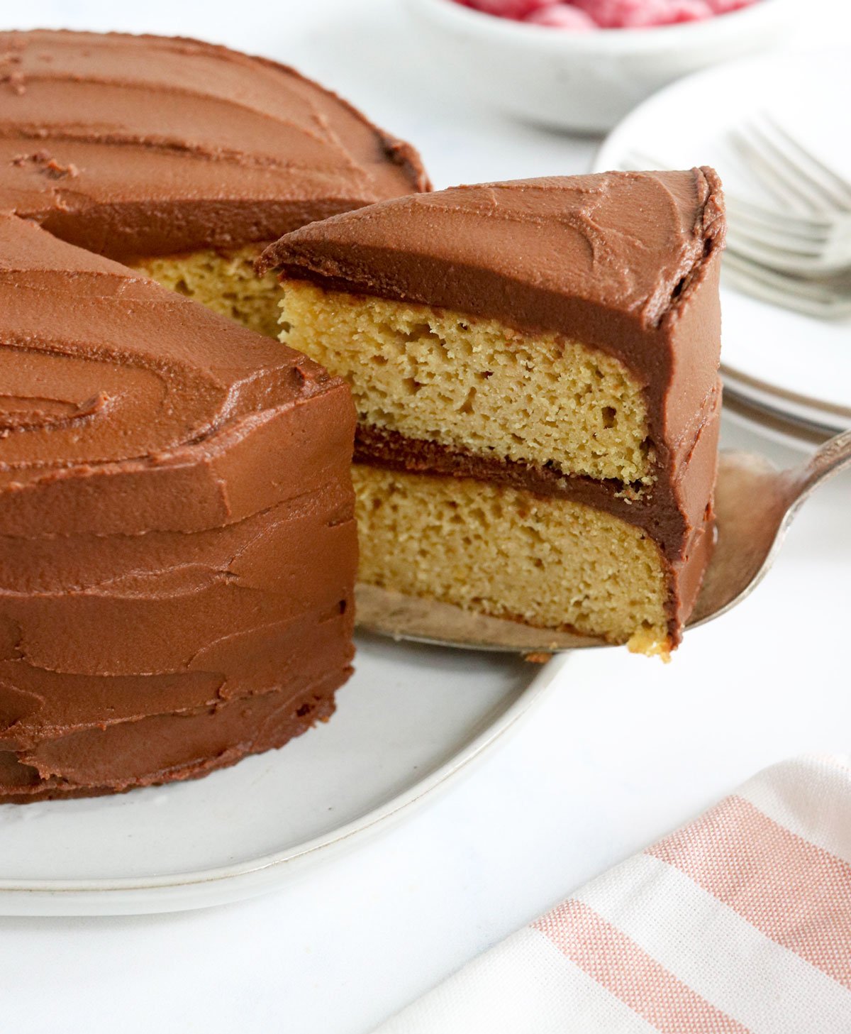 a slice of almond flour cake with chocolate frosting is being lifted out