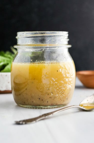 apple cider vinaigrette in glass jar with black background