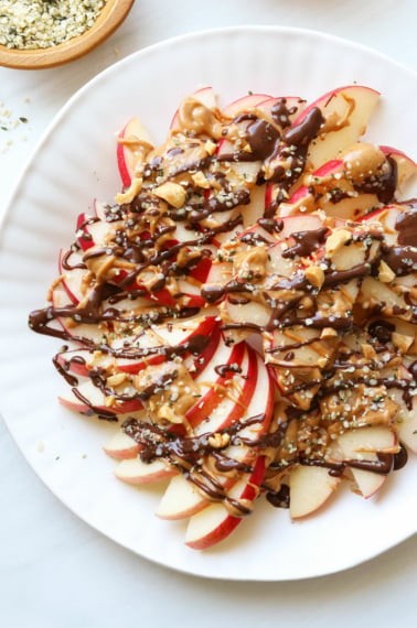 apple nachos arranged on a white plate.