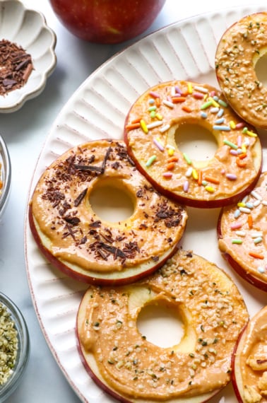 apple "donuts" on a plate with fun toppings.