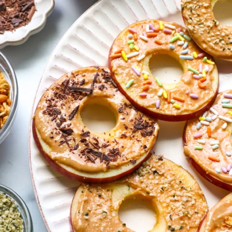 apple "donuts" on a plate with fun toppings.