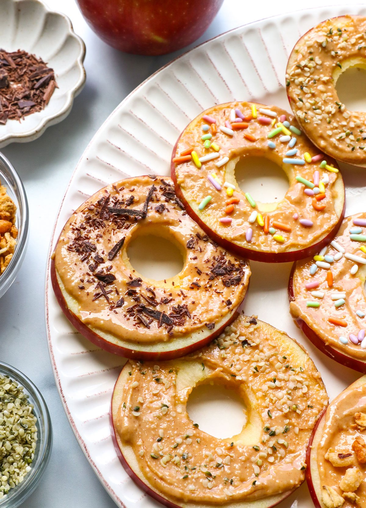 apple "donuts" on a plate with fun toppings. 