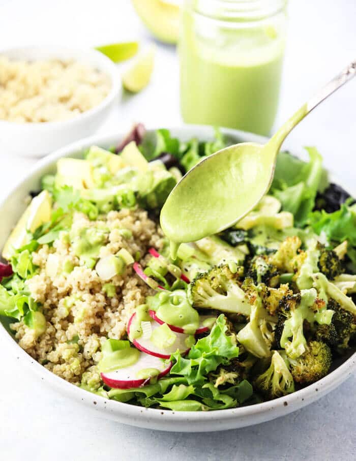 Healthy avocado cilantro dressing over a summer salad