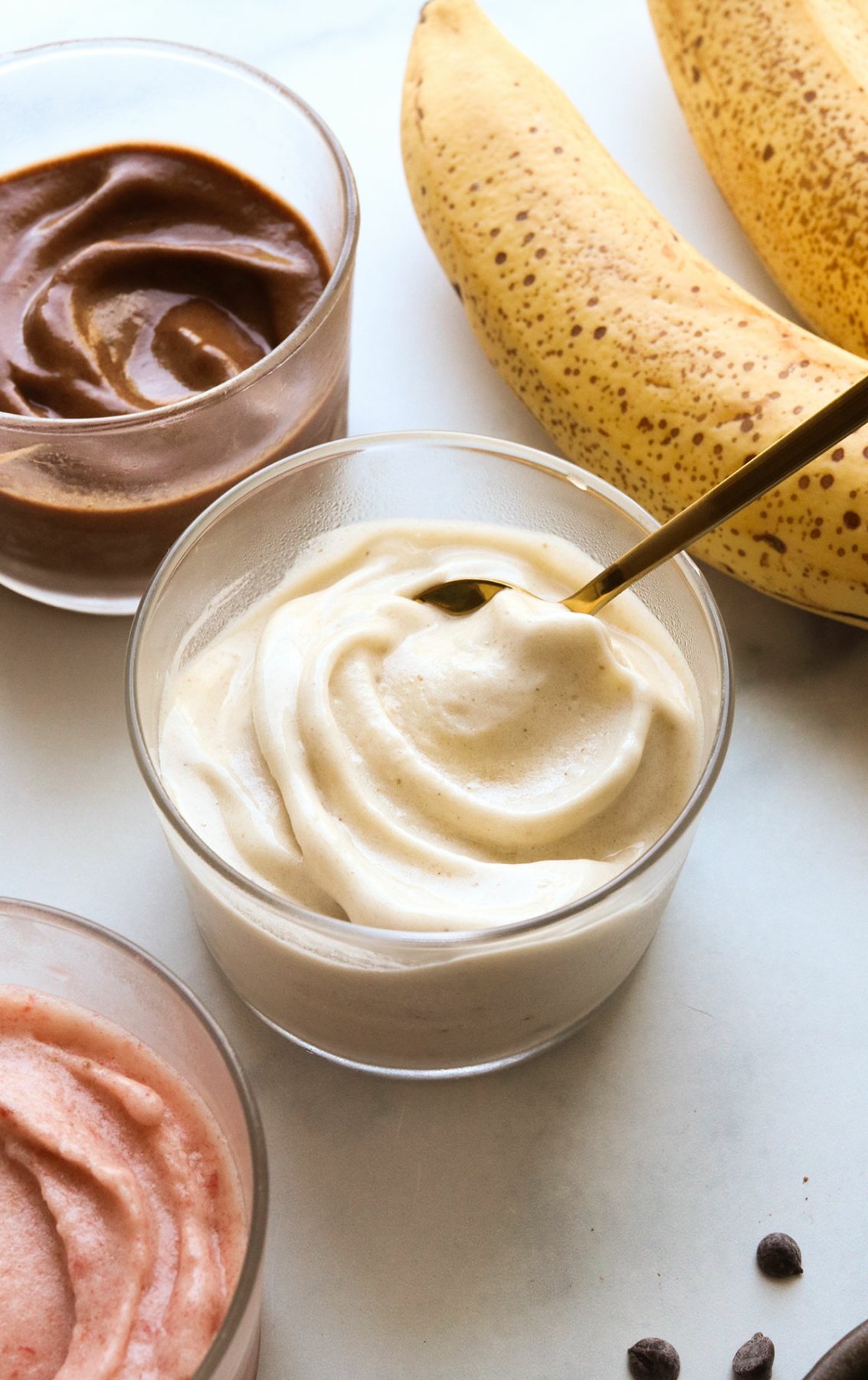 banana ice cream with a spoon inside a glass bowl.