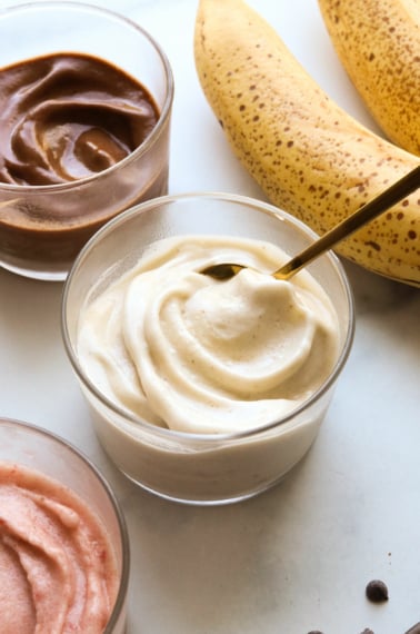 banana ice cream with a spoon inside a glass bowl.