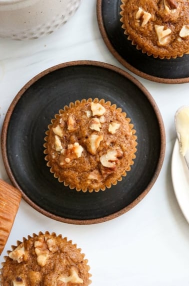 healthy banana muffins on black plates overhead.