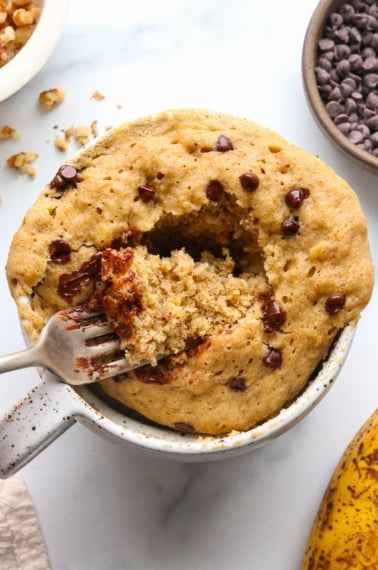 banana mug cake topped with chocolate chips close-up with a fork.