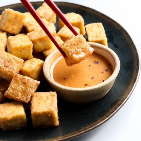 baked tofu dipped in sauce