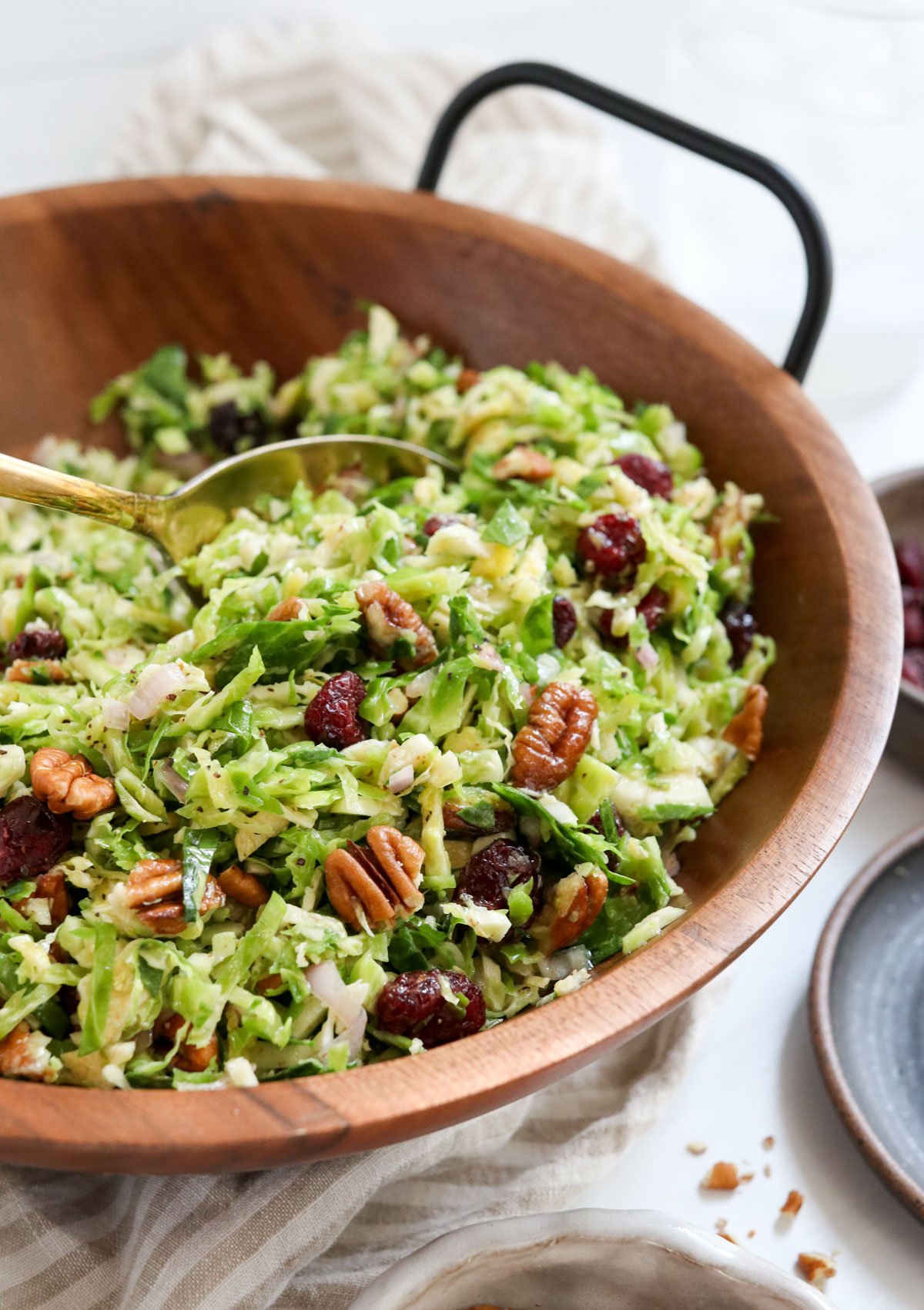 brussels sprouts salad served in wooden bowl with gold spoon