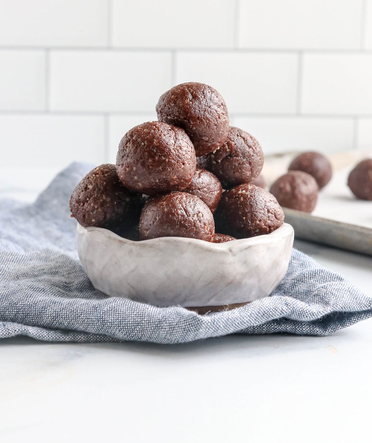 chocolate date balls in white bowl