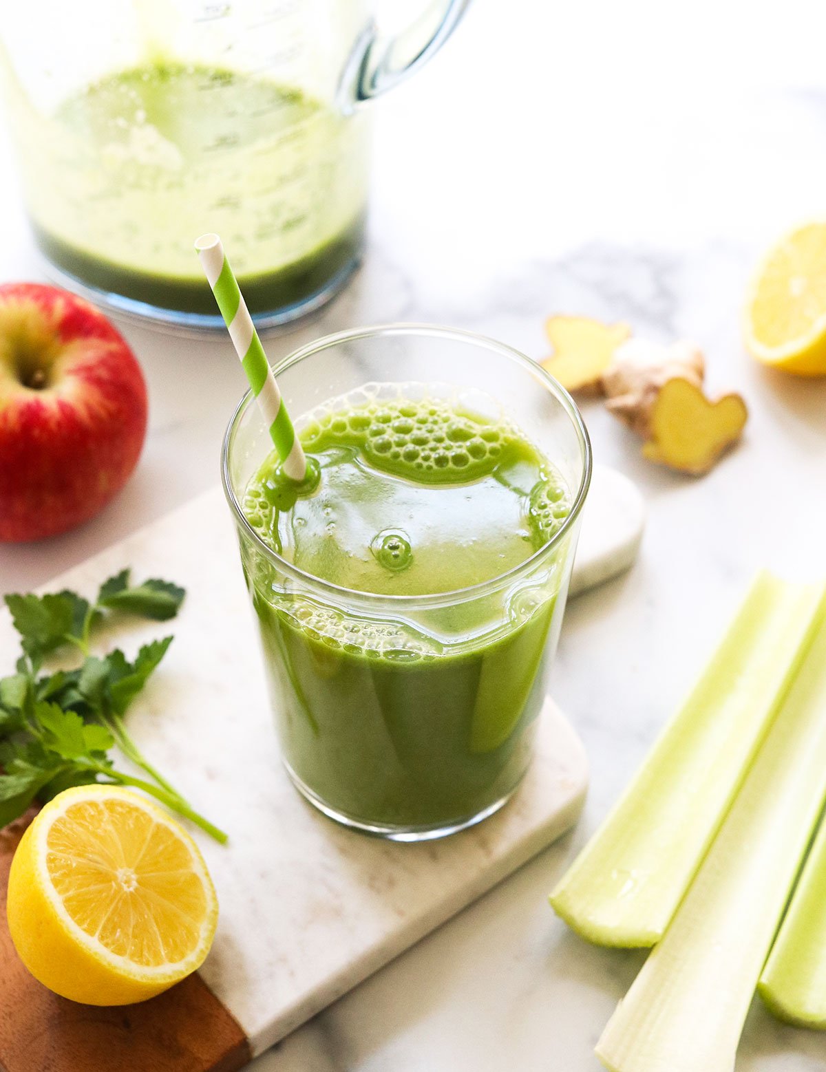 detox juice served in a glass with a striped straw.