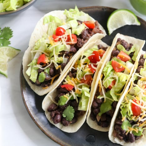 black bean tacos on black plate.