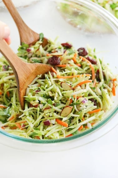 broccoli slaw tossed with wooden tongs