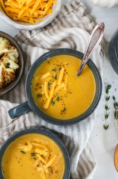 cauliflower cheese soup in dark blue mugs.