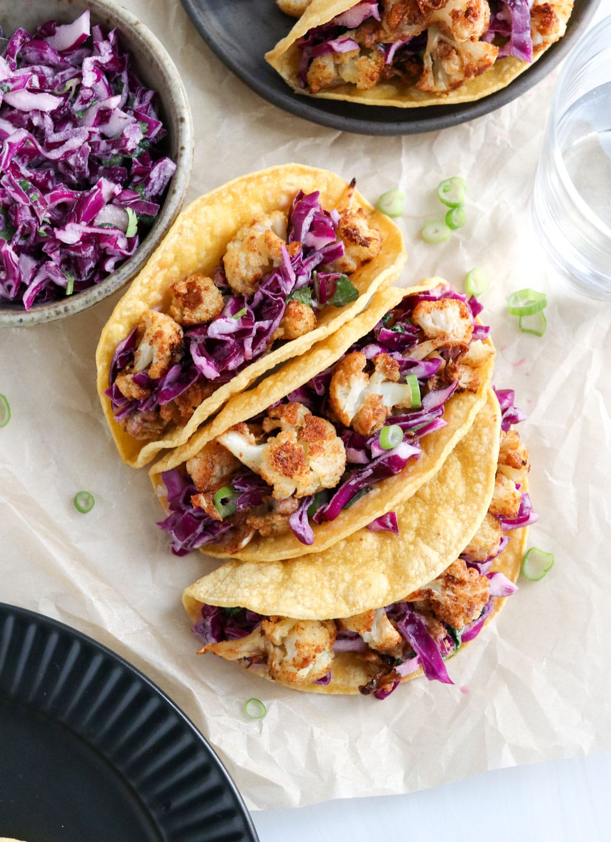 cauliflower tacos on parchment paper with purple slaw