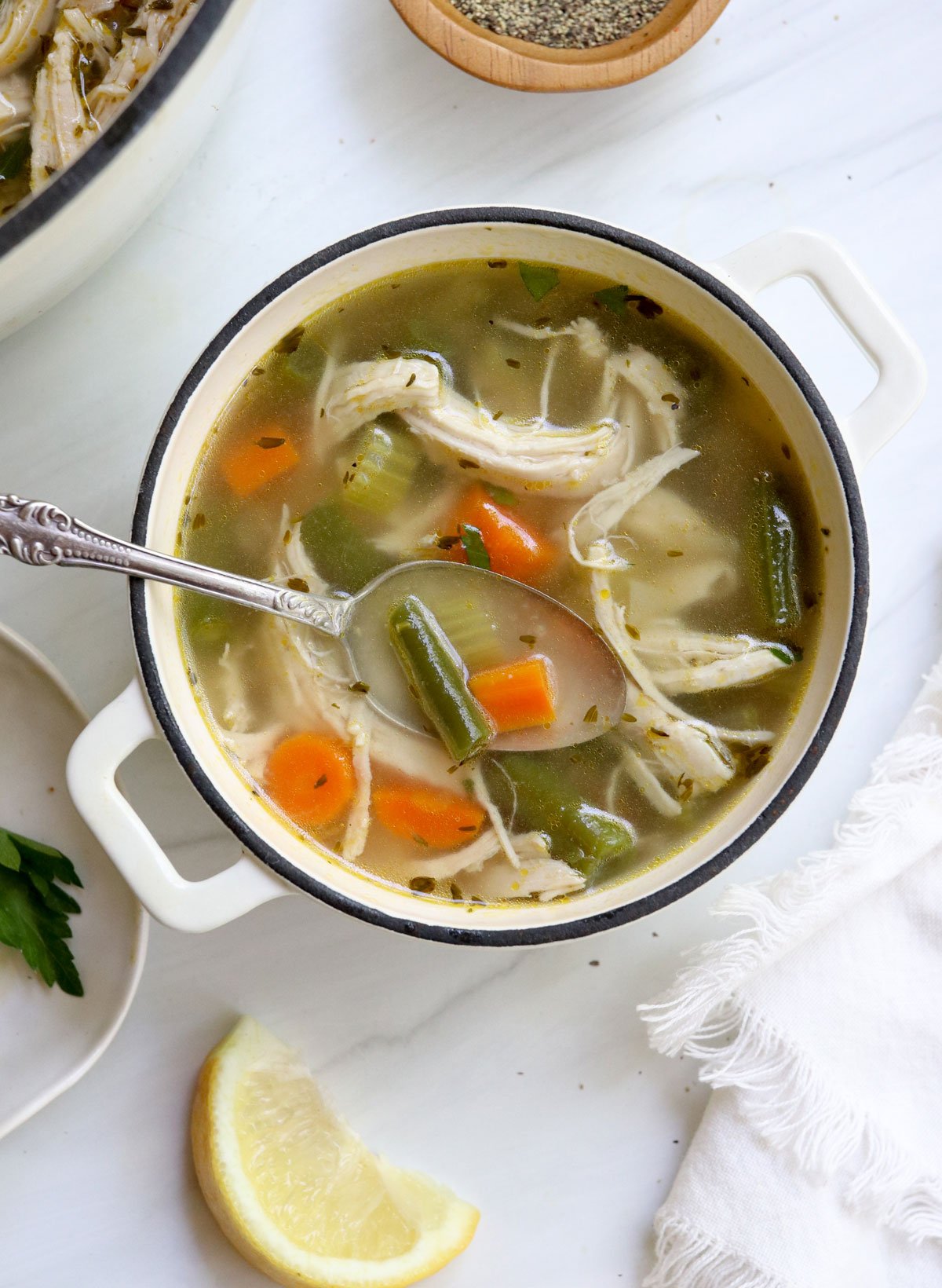 chicken soup served in a bowl with a spoon.