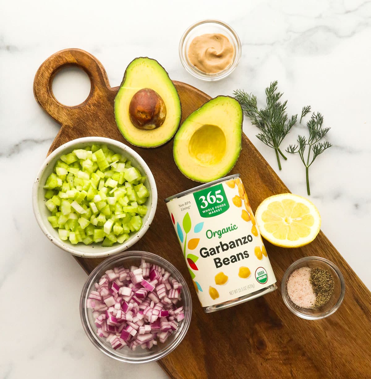 chickpea salad sandwich ingredients laying on a cutting board.