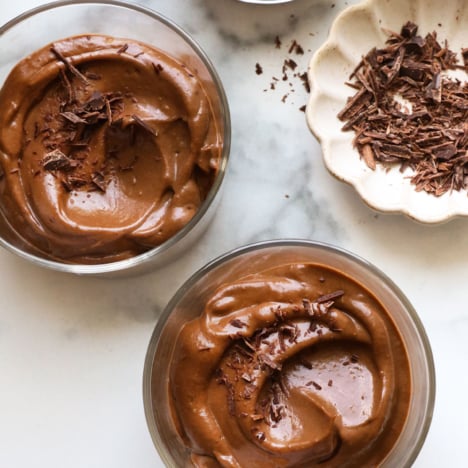 chocolate avocado pudding served in 3 glass jars.