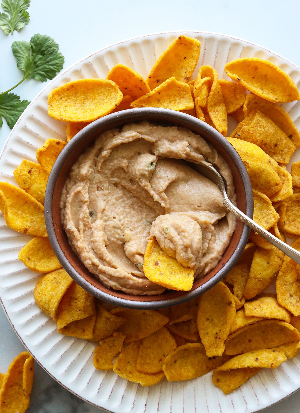 bean dip served with organic corn chips and fresh cilantro.