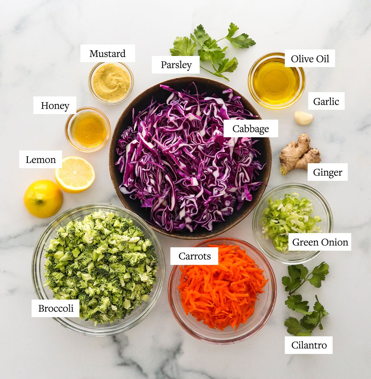 detox salad ingredients in glass bowls labeled on a white surface.