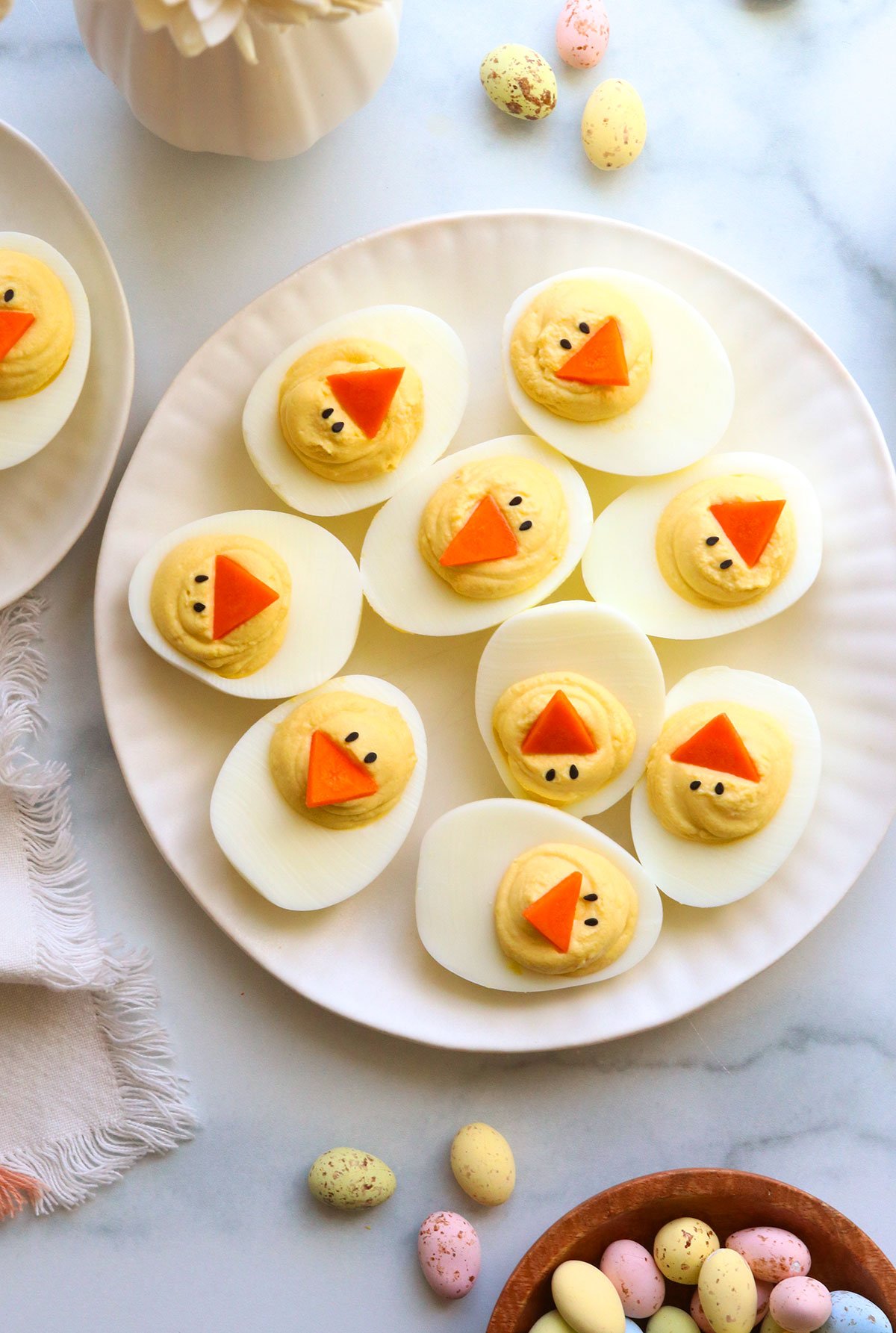 Easter deviled eggs served on a white plate overhead.