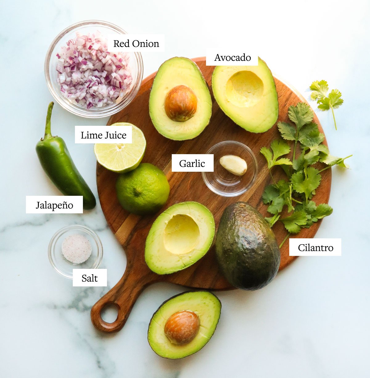 guacamole ingredients labeled on a cutting board.