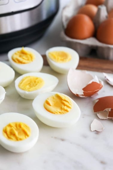 hard boiled eggs cut open with the peeled shell nearby