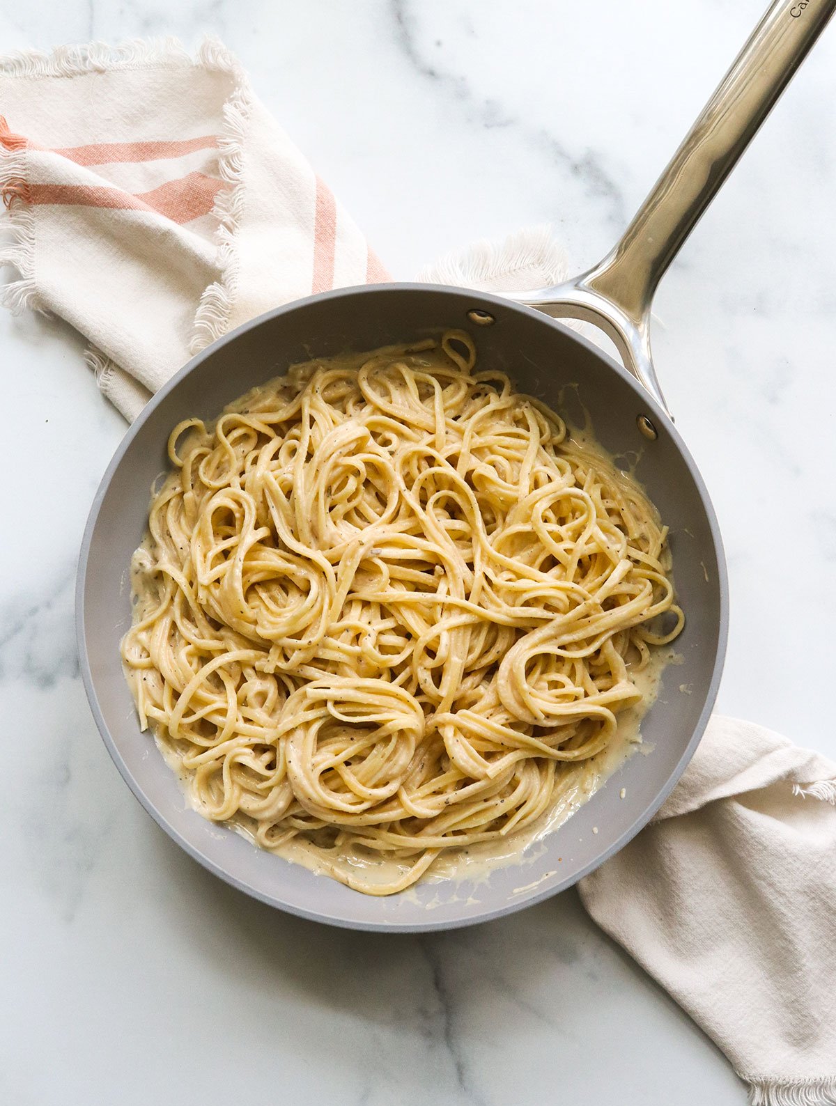 pasta tossed in the creamy hummus sauce in pan.