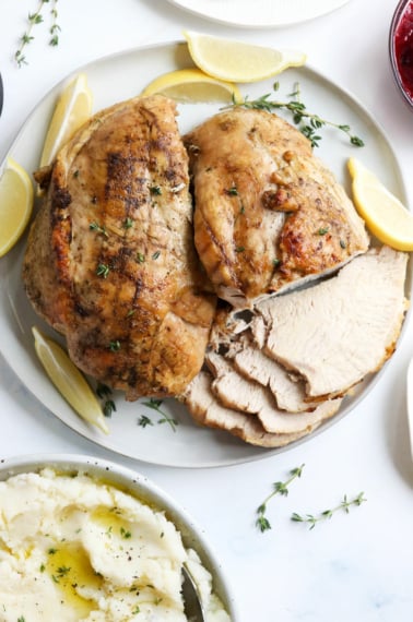 Cooked turkey breast on a white platter