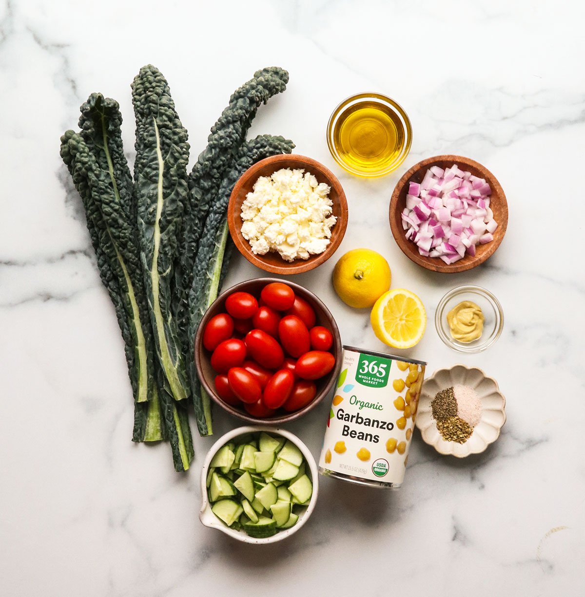 kale and chopped veggies laying on a marble surface.