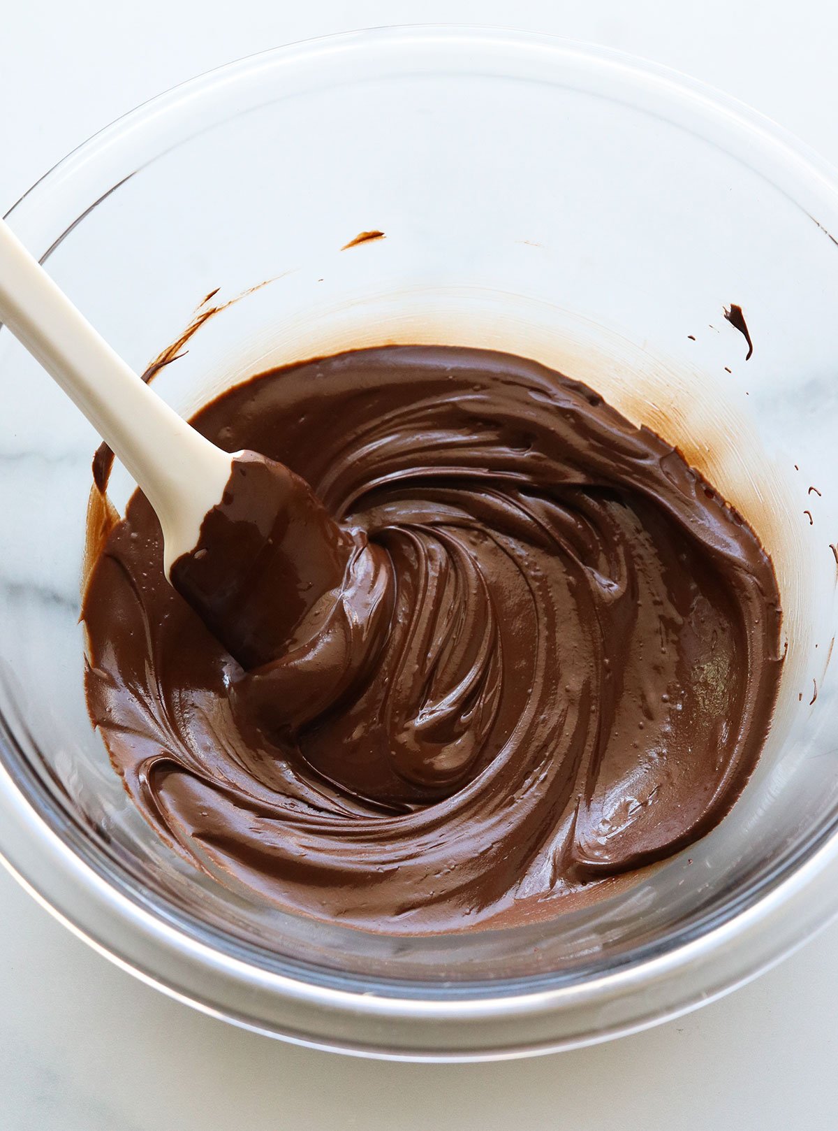 melted chocolate chips stirred in a glass bowl.