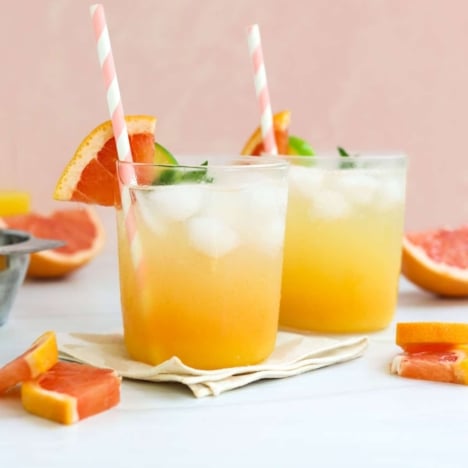 two mocktails in front of a peach background.