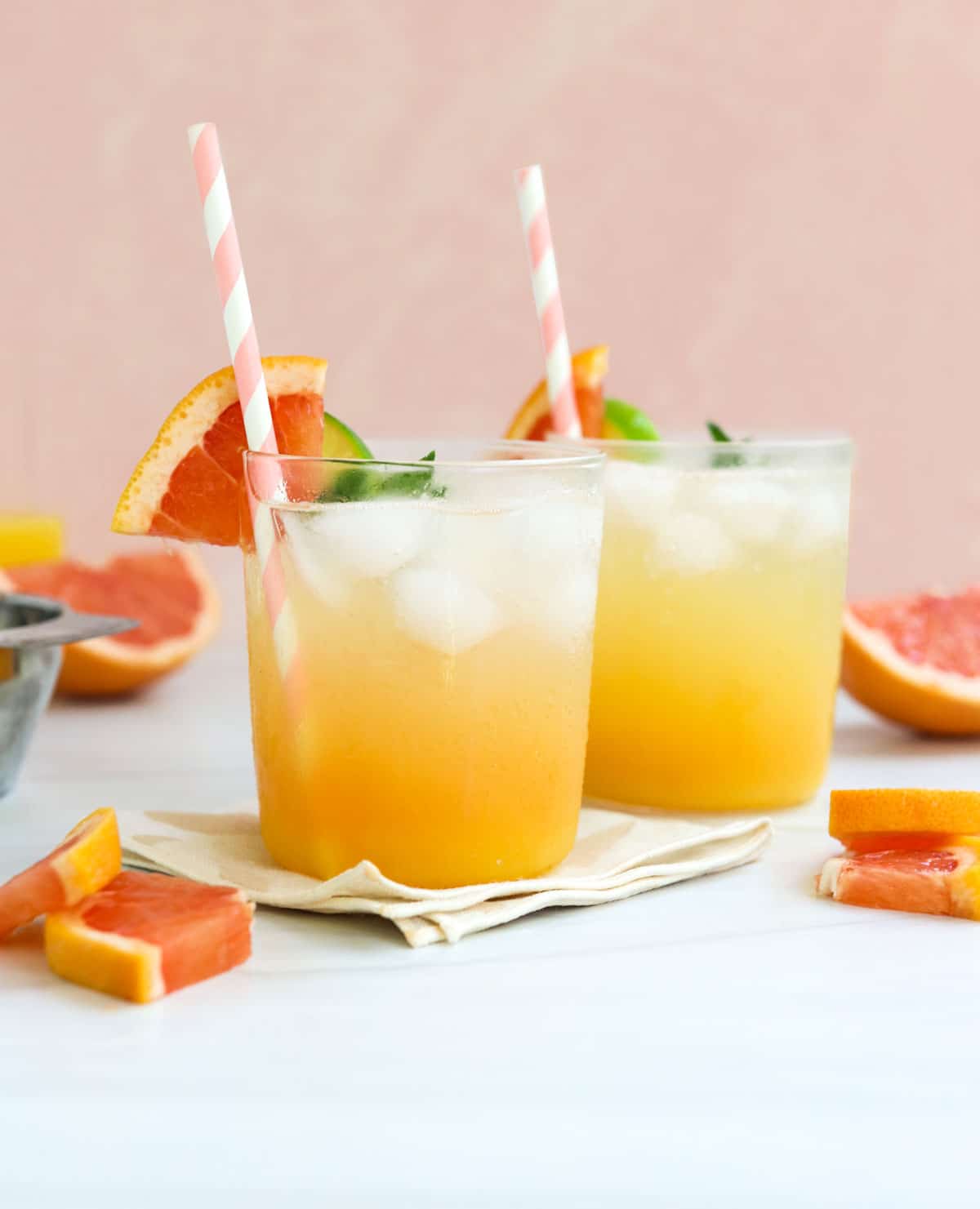 two mocktails in front of a peach background.