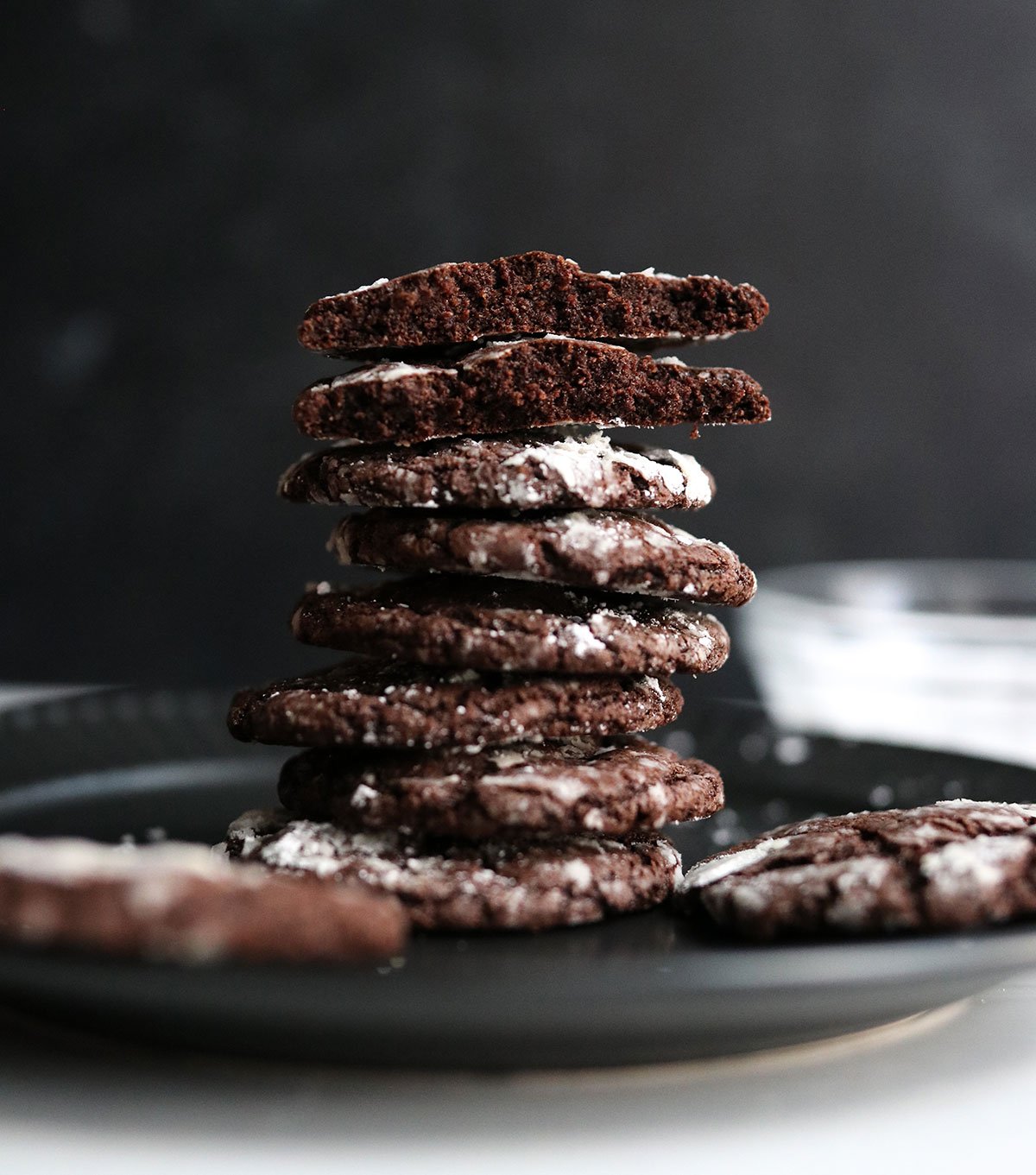 oat flour chocolate cookies stacked on black plate.