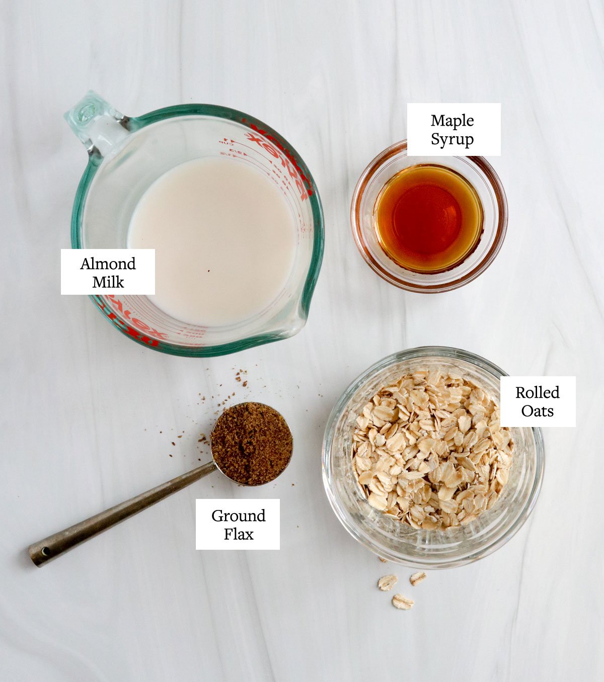 overnight oats base ingredients in glass bowls on white surface