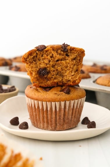 Paleo pumpkin muffins stacked on a white plate.