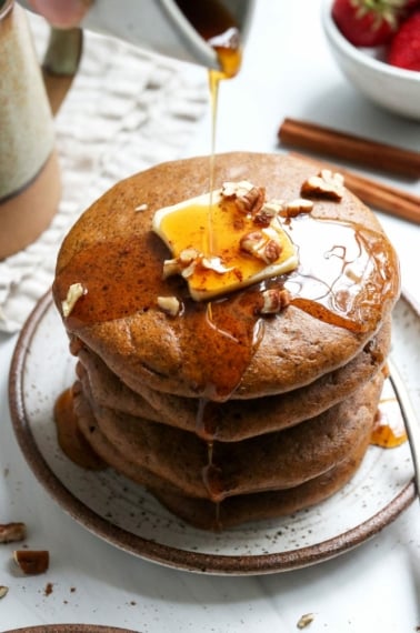 paleo pumpkin pancakes stacked with butter and syrup poured on top