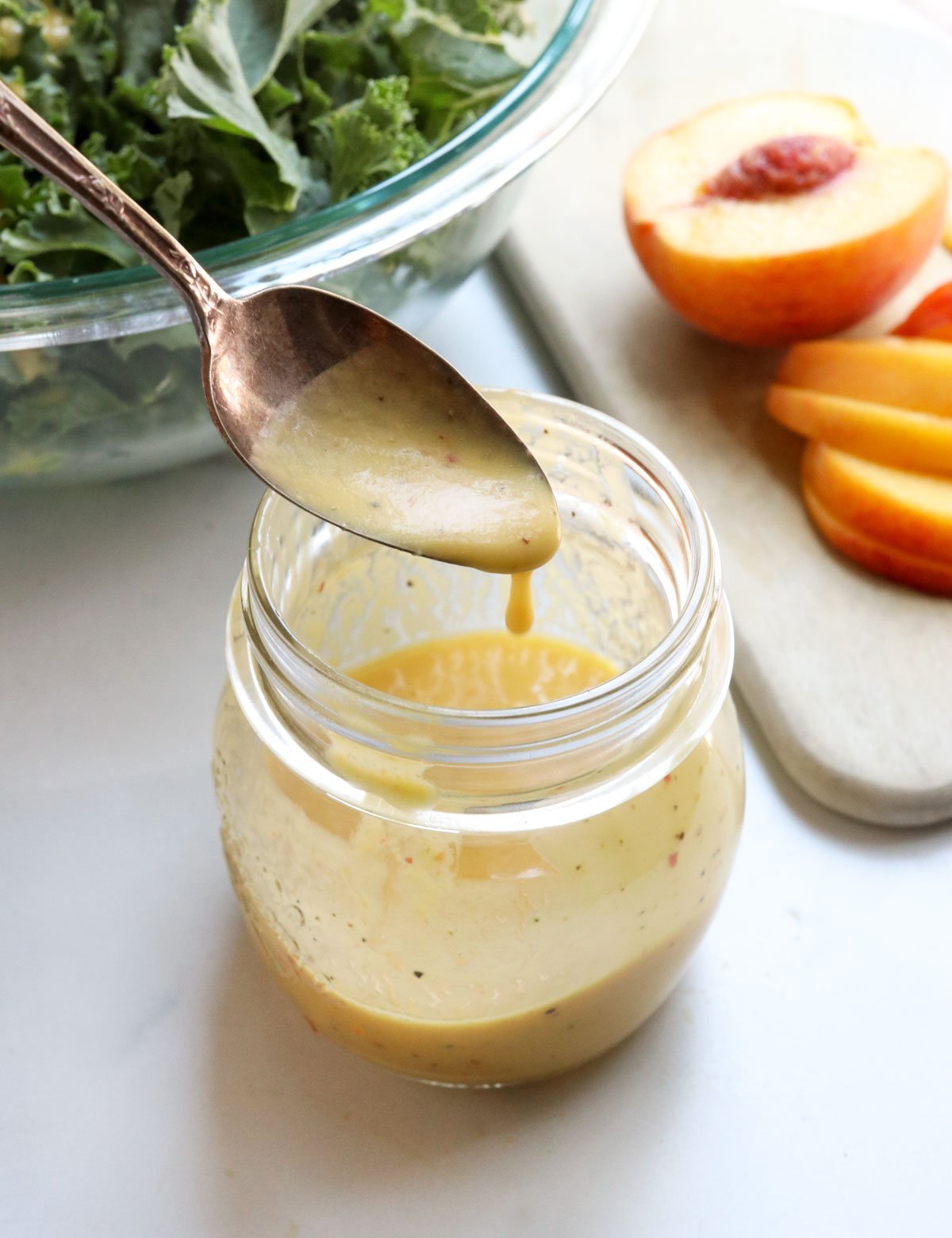 peach dressing dripping off of a spoon