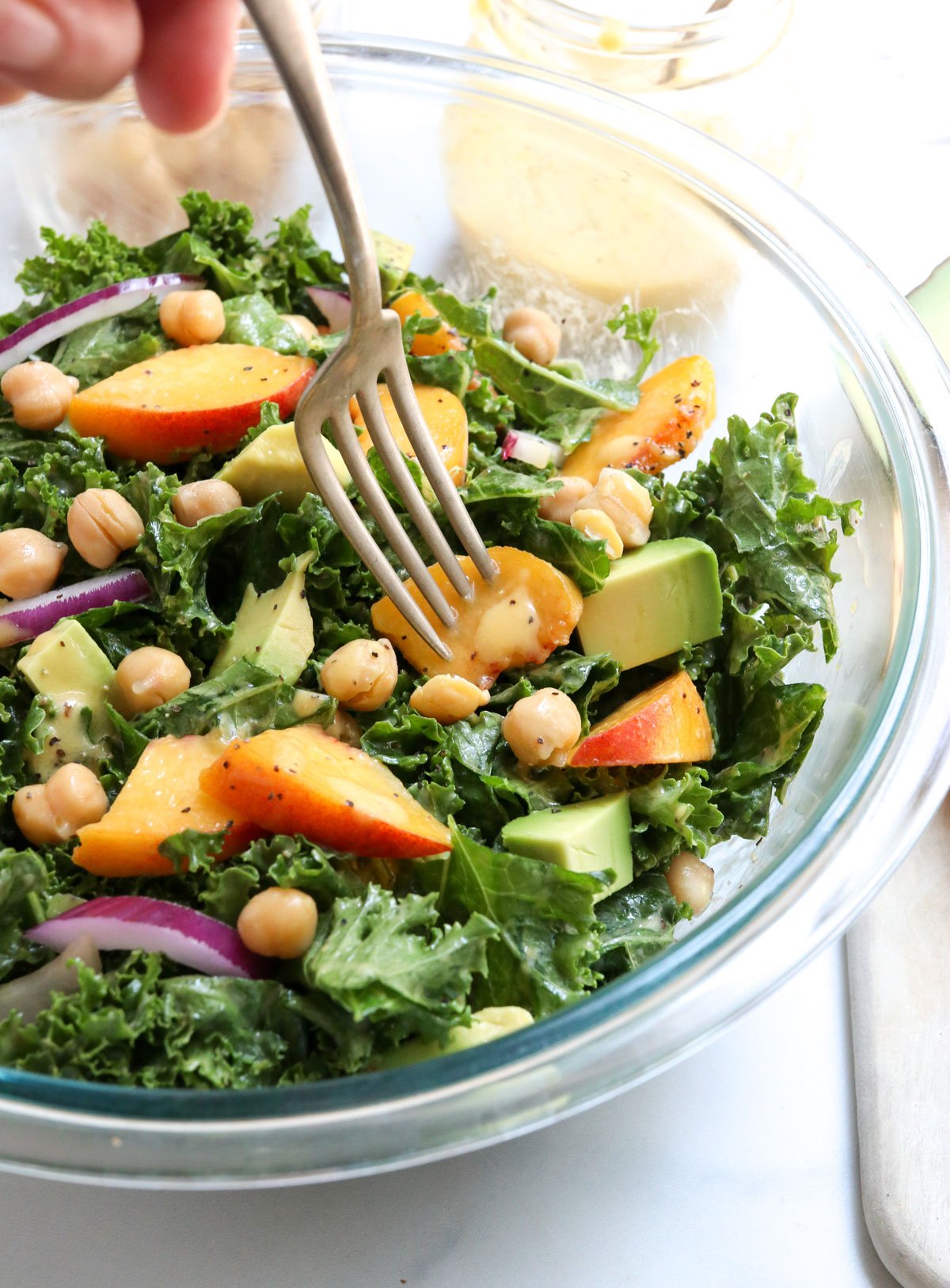 fork digging into peach salad