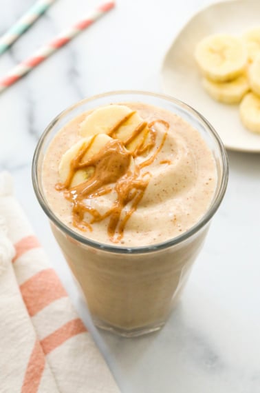 peanut butter banana smoothie topped with peanut butter drizzle.