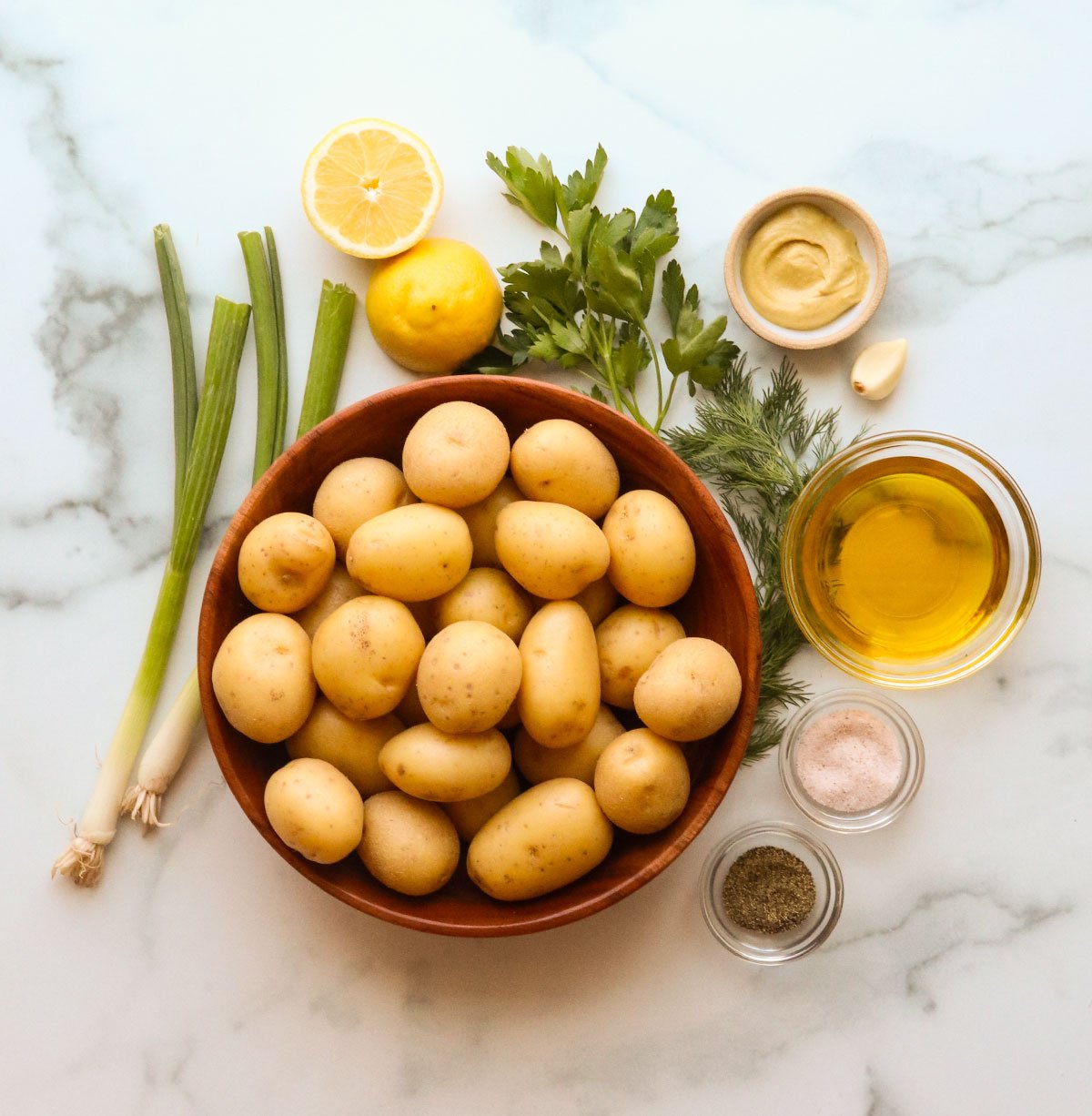 no mayo potato salad ingredients on a marble counter.