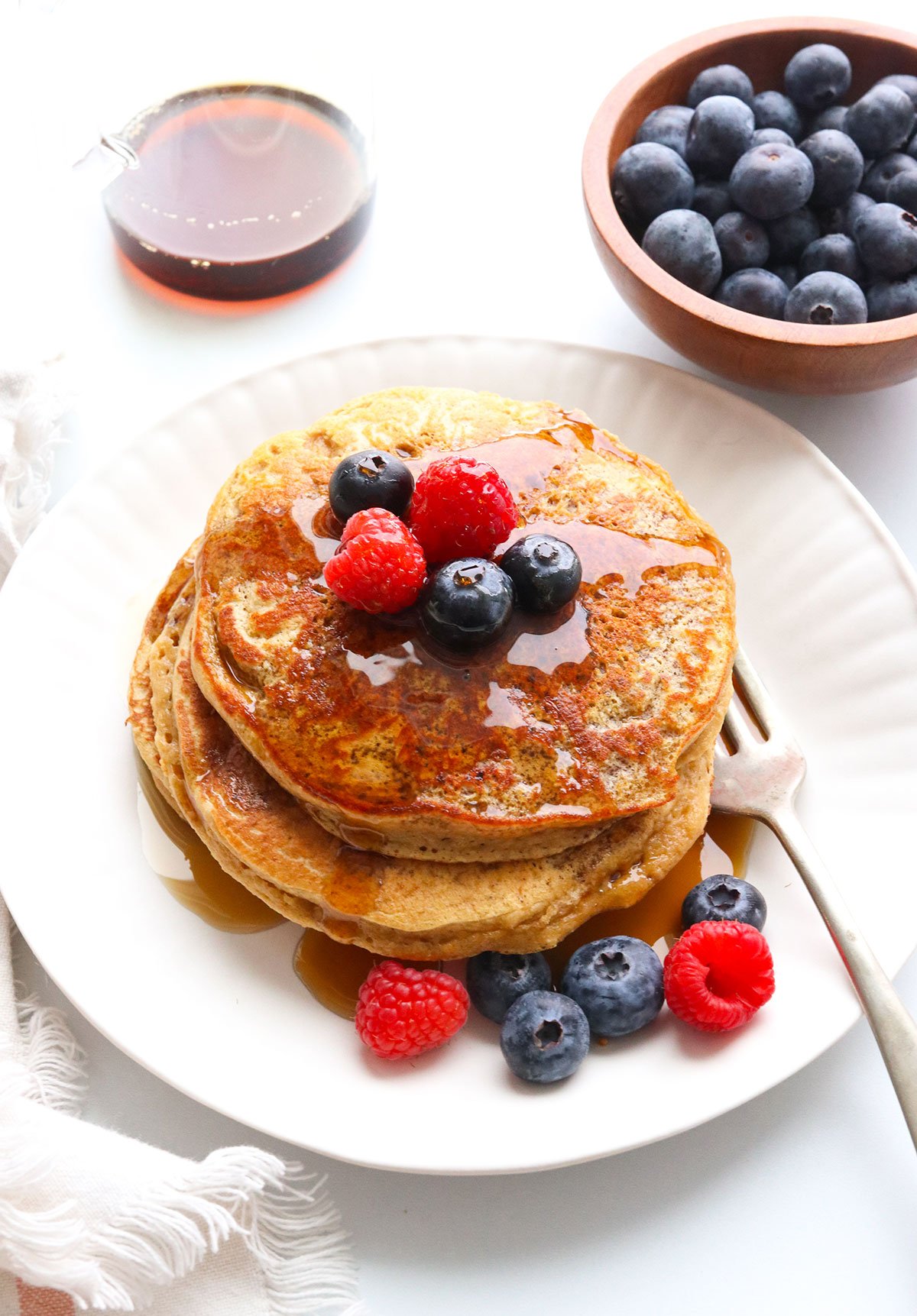 protein pancakes served on a plate with fruit.