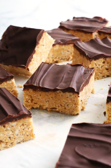 protein rice crispy square topped with a chocolate coating on parchment paper.