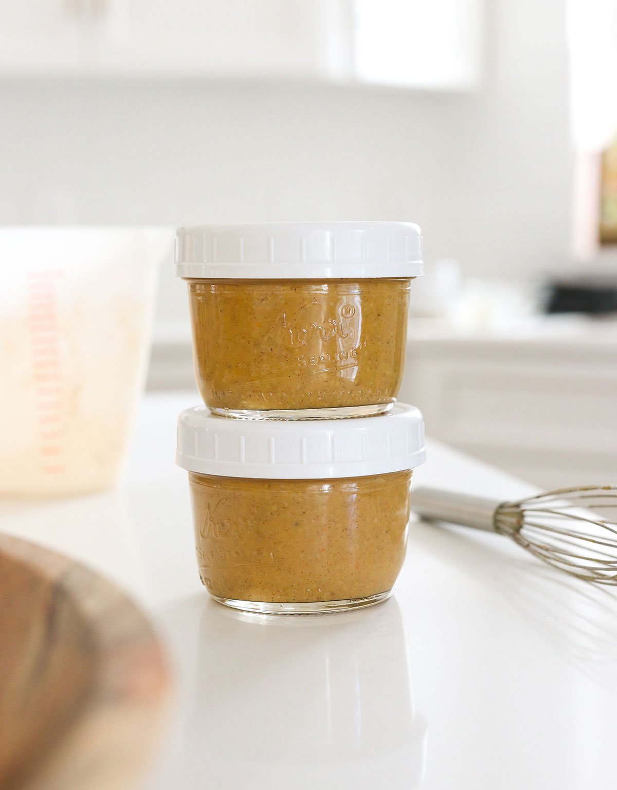 two jars of chia pudding stacked with lids on.