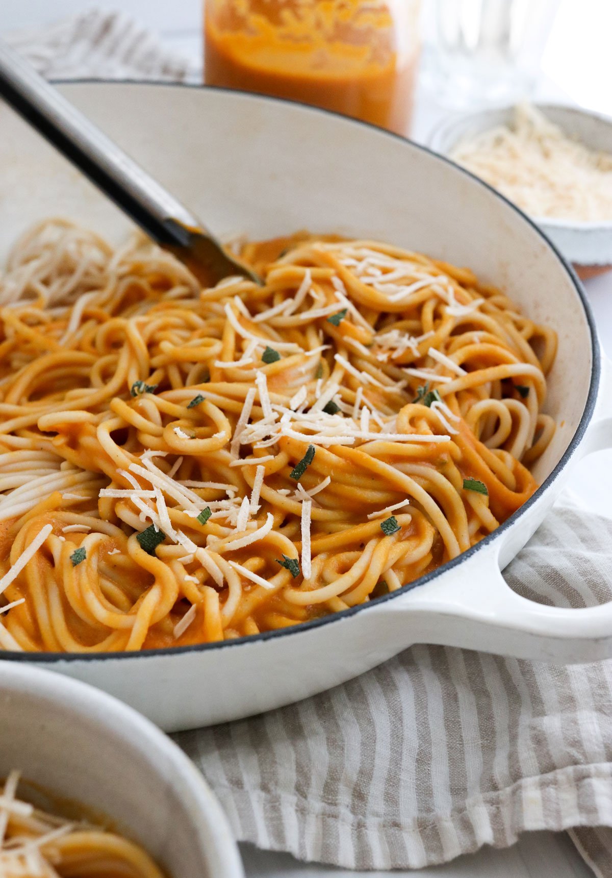 pumpkin pasta in skillet topped with parmesan