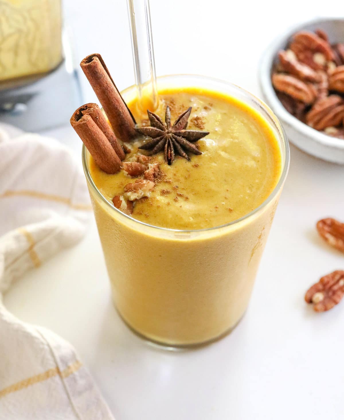 pumpkin smoothie in glass with cinnamon sticks