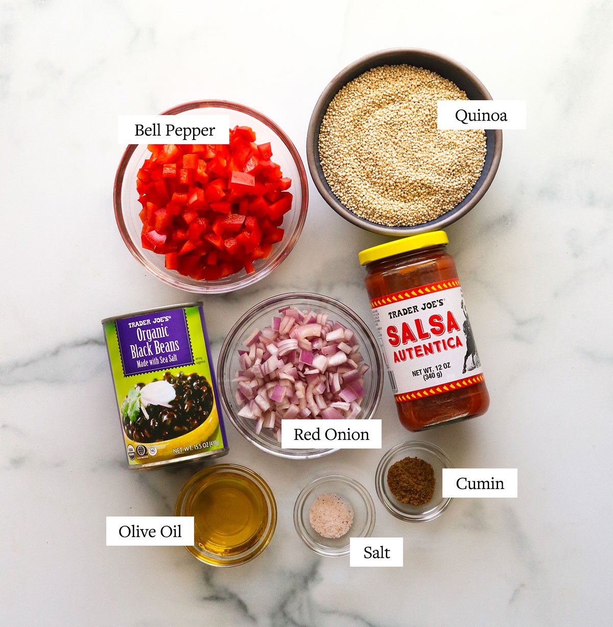 quinoa burrito bowl ingredients labeled on a marble surface.